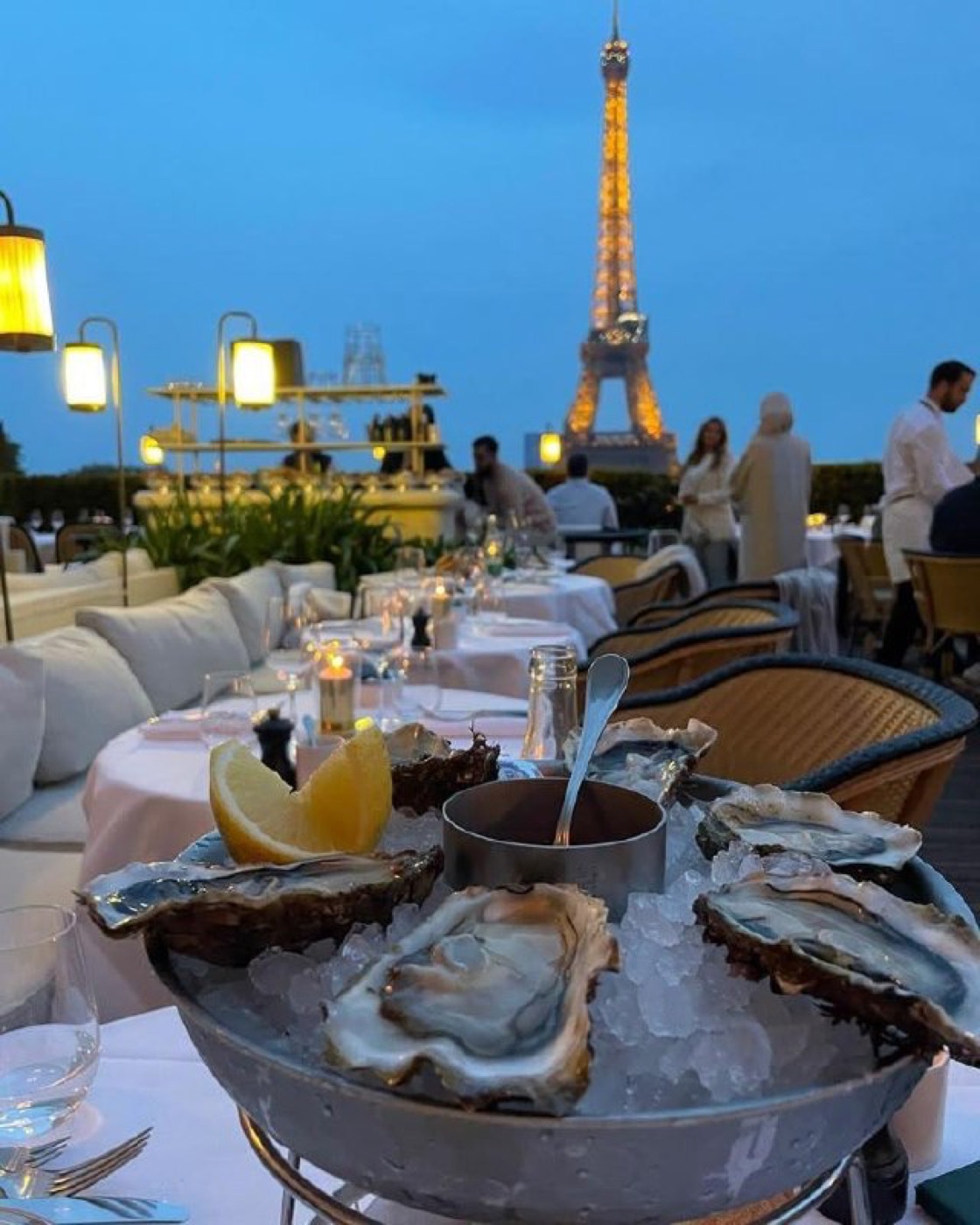 Bandeja de ostras no terraço do Girafe com a Torre Eiffel iluminada ao fundo