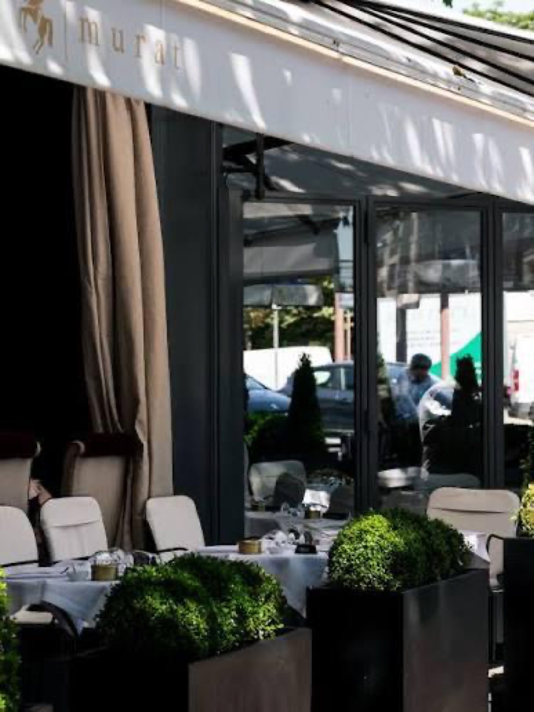 O terraço do Le Murat, com o toldo claro e as mesas postas