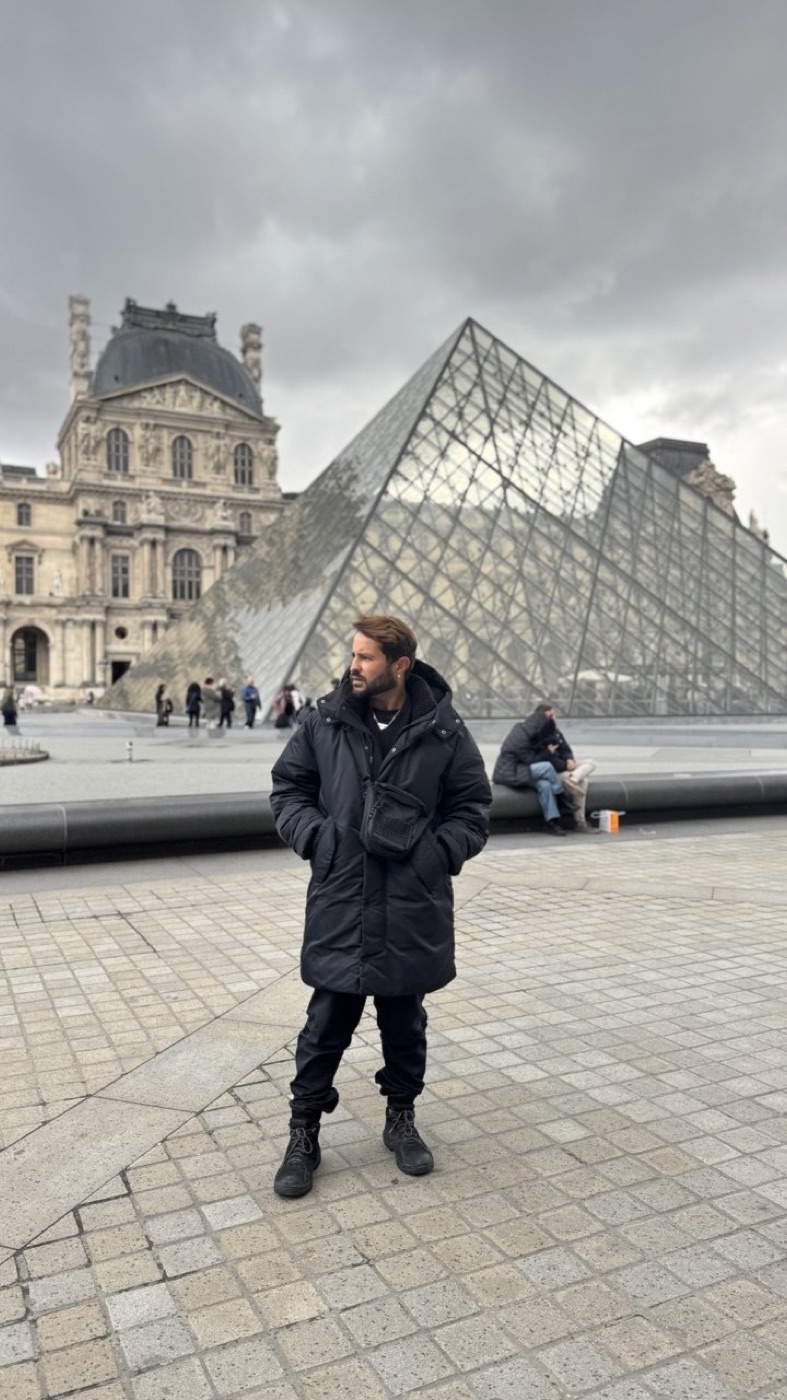 O Dan em frente à pirâmide de vidro do Louvre