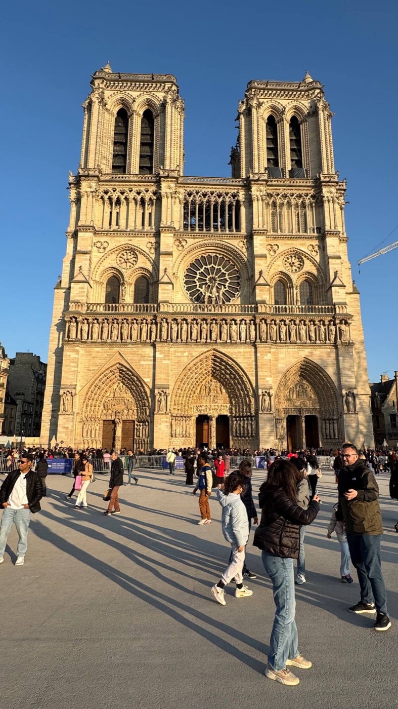A fachada da catedral de Notre-Dame no fim de tarde, com a praça cheia