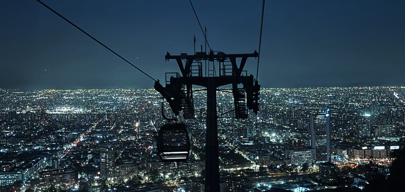 Santiago iluminada à noite, com a cordilheira ao fundo