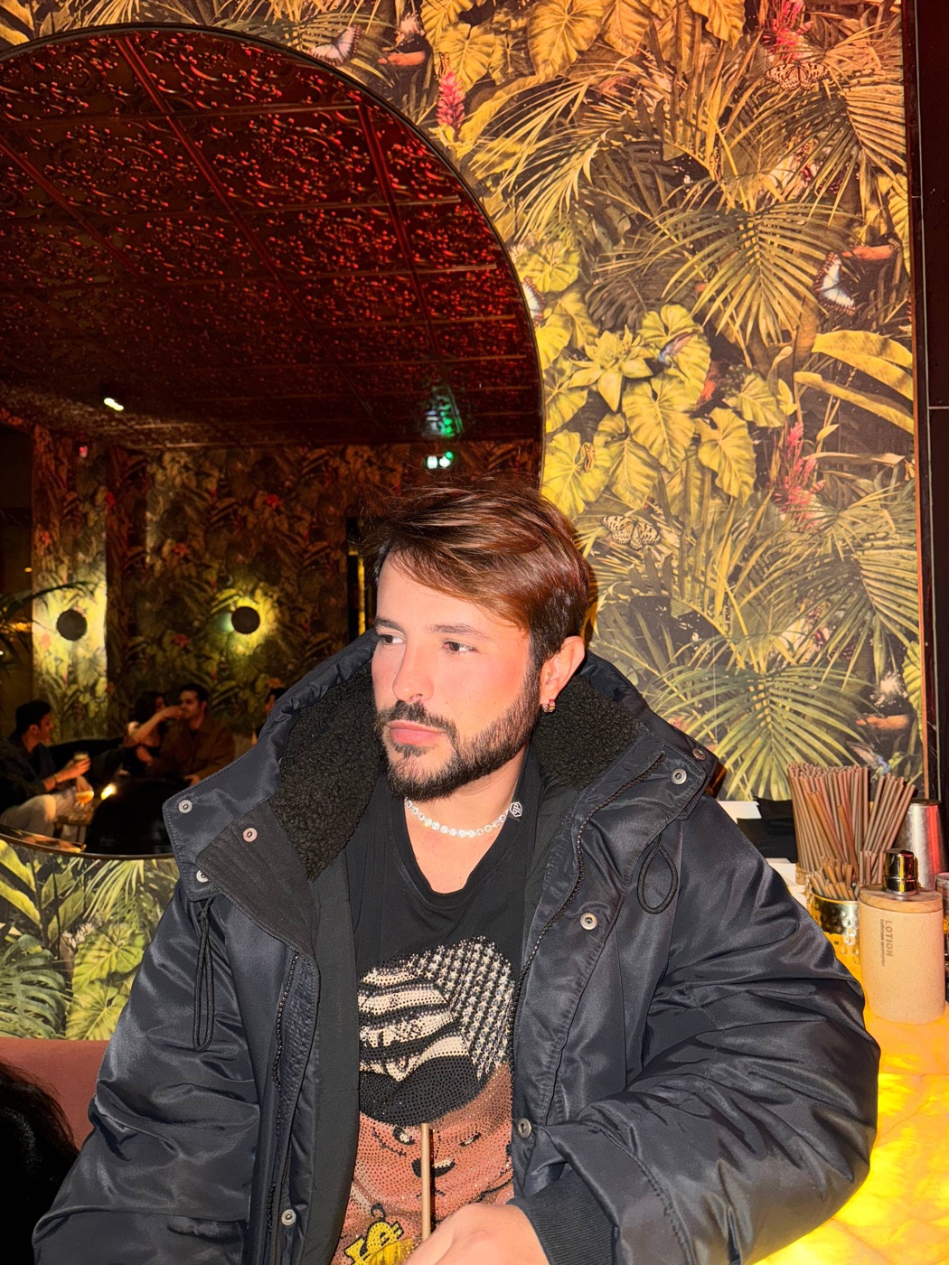 O Dan no Verde Paris, com o papel de parede de selva do salão atrás