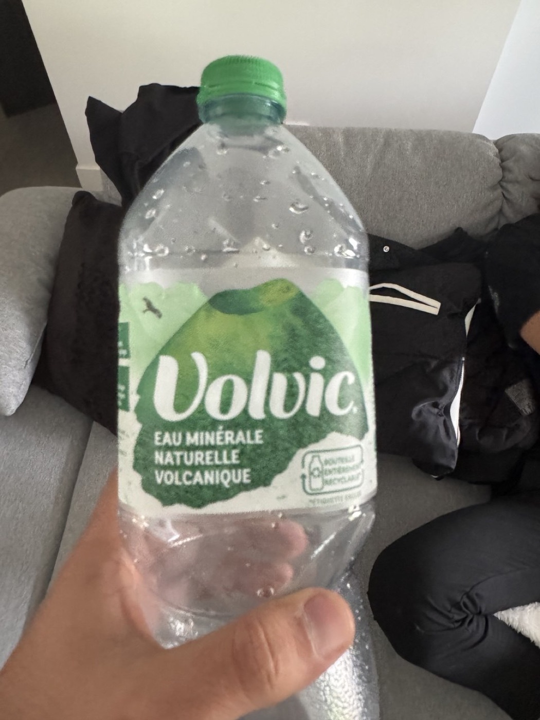 A garrafa de Volvic na mão do Dan